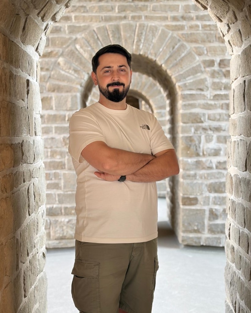 Marius, standing in a stone arcade